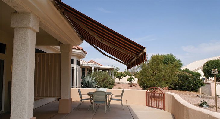 Eclipse automatic retractable sun shade covering a large patio with motorized operation and custom striped fabric